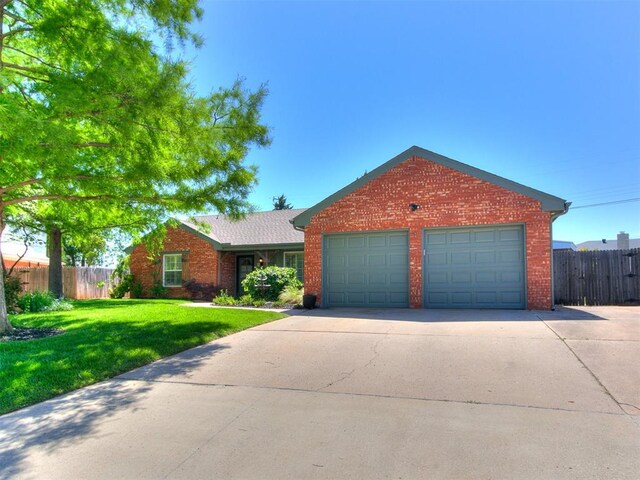 6709 Reed Dr, Oklahoma City, OK 73116 - ranch-style home featuring brick siding, an attached garage, and driveway