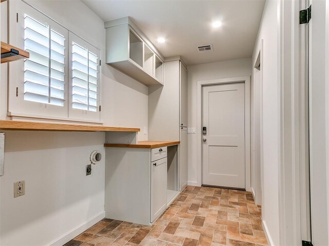 6709 Reed Dr, Oklahoma City, OK 73116 - laundry area with stone finish flooring, electric dryer hookup, baseboards, and cabinet space
