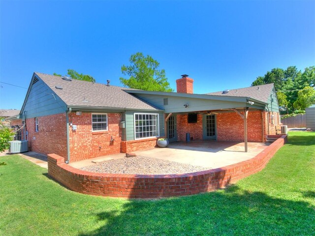 6709 Reed Dr, Oklahoma City, OK 73116 - back of property with a chimney, brick siding, a patio, central air condition unit, and roof with shingles
