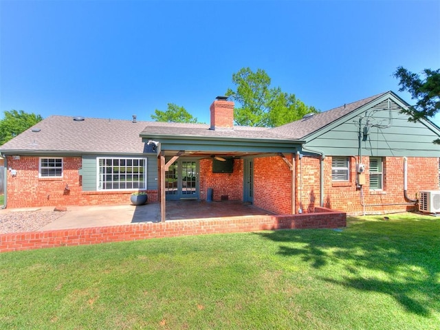6709 Reed Dr, Oklahoma City, OK 73116 - back of house with a chimney, brick siding, a cooling unit, a patio, and a yard
