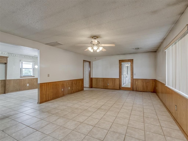 2915 N W Oaks Pl, Newcastle, OK 73065 - unfurnished room with a wainscoted wall, wood walls, ceiling fan, and a textured ceiling
