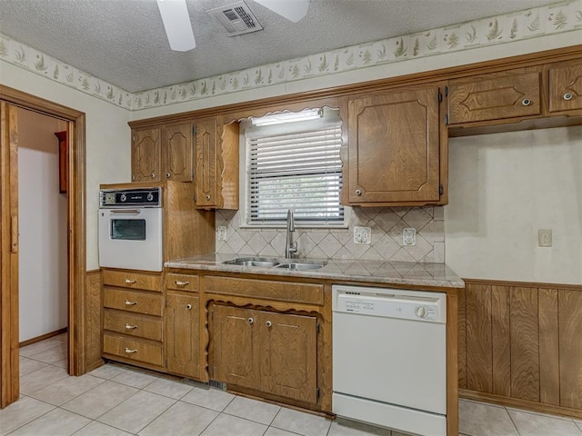 2915 N W Oaks Pl, Newcastle, OK 73065 - kitchen with white appliances, a sink, ceiling fan, brown cabinets, and a textured ceiling