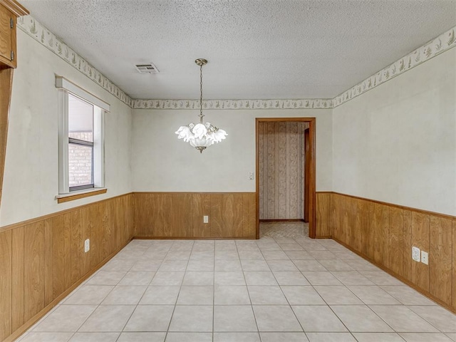 2915 N W Oaks Pl, Newcastle, OK 73065 - spare room featuring wood walls, wainscoting, a chandelier, and a textured ceiling
