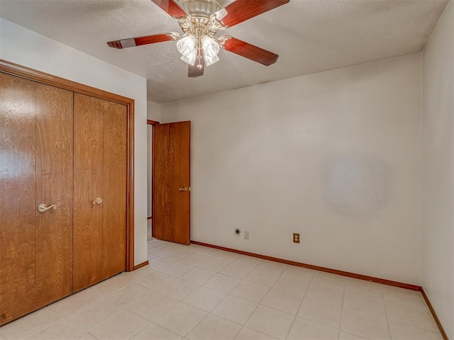 2915 N W Oaks Pl, Newcastle, OK 73065 - unfurnished bedroom with baseboards, a textured ceiling, a ceiling fan, and a closet