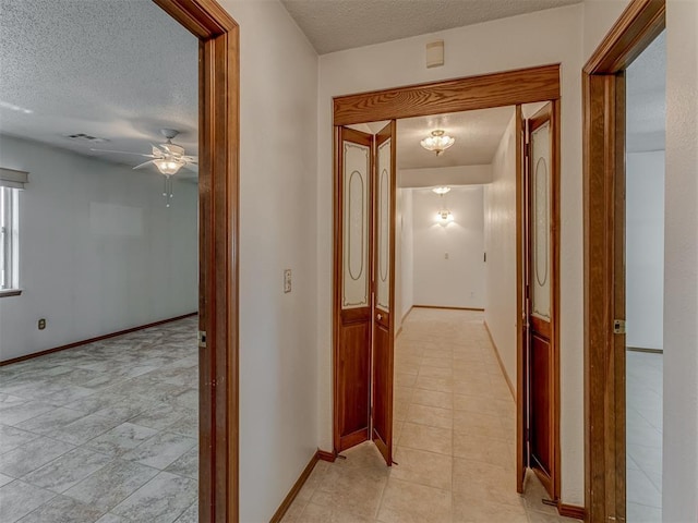 2915 N W Oaks Pl, Newcastle, OK 73065 - corridor with a textured ceiling, light tile patterned floors, and baseboards