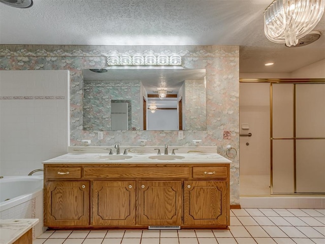 2915 N W Oaks Pl, Newcastle, OK 73065 - bathroom featuring tile patterned floors, a stall shower, a textured ceiling, a bath, and double vanity