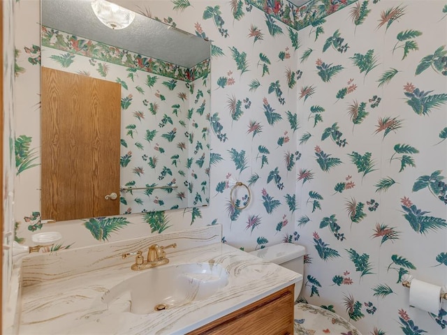 2915 N W Oaks Pl, Newcastle, OK 73065 - bathroom featuring wallpapered walls, toilet, and vanity