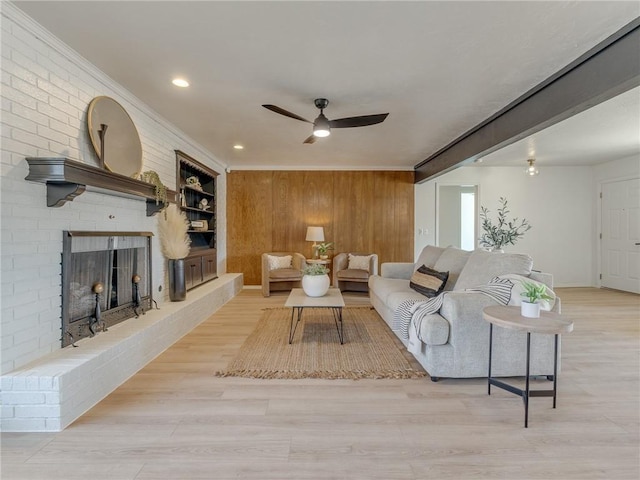 5613 NW 115th St, Oklahoma City, OK 73162 - living area with a ceiling fan, wooden walls, a brick fireplace, wood finished floors, and ornamental molding