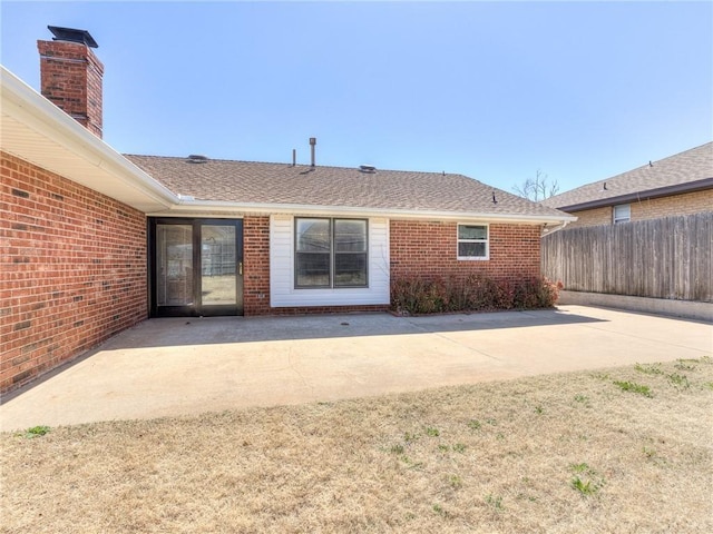 5613 NW 115th St, Oklahoma City, OK 73162 - back of property featuring a patio, fence, brick siding, and a shingled roof
