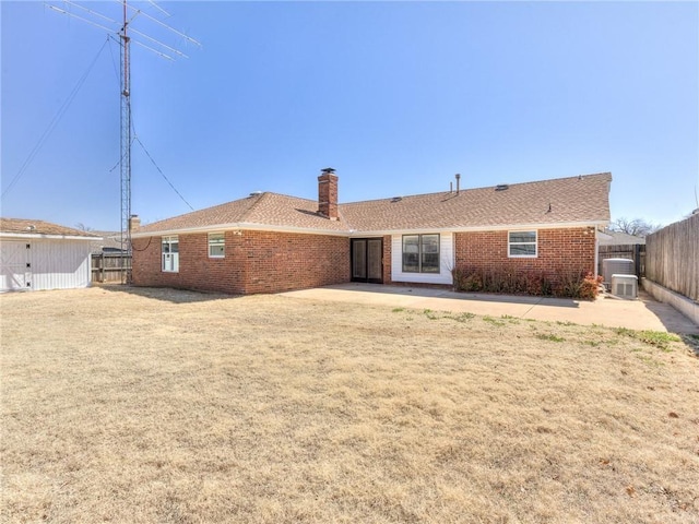 5613 NW 115th St, Oklahoma City, OK 73162 - back of property featuring brick siding, a chimney, cooling unit, and a patio area