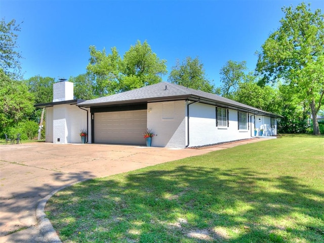 6501 N Laird Ave, Oklahoma City, OK 73105 - view of property exterior with an attached garage, a chimney, brick siding, driveway, and a yard