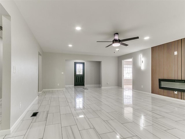 6501 N Laird Ave, Oklahoma City, OK 73105 - unfurnished room with a ceiling fan, recessed lighting, a glass covered fireplace, and baseboards