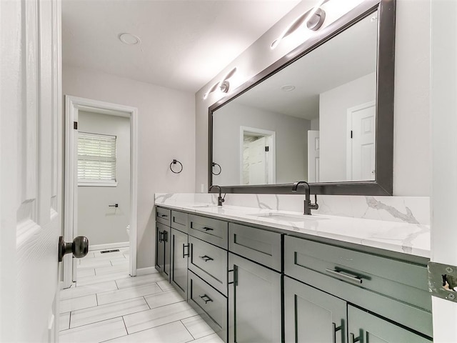 6501 N Laird Ave, Oklahoma City, OK 73105 - bathroom featuring double vanity, baseboards, and toilet