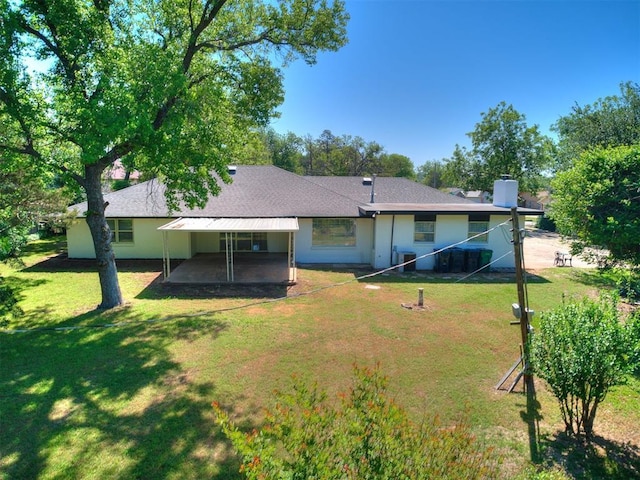 6501 N Laird Ave, Oklahoma City, OK 73105 - rear view of house featuring a patio, a lawn, a chimney, and a carport