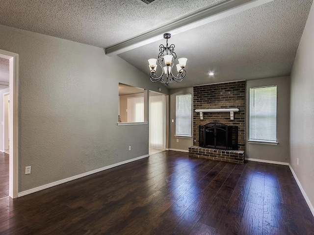 unfurnished living room featuring wood-type flooring, plenty of natural light, a textured ceiling, a chandelier, and a textured wall