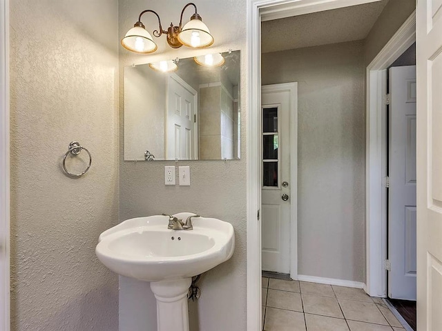 bathroom with tile patterned floors and a textured wall