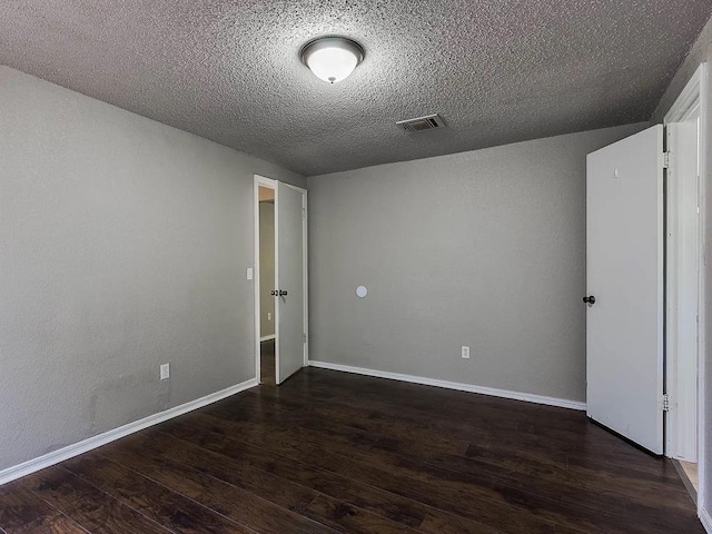 empty room featuring wood finished floors, a textured ceiling, and baseboards