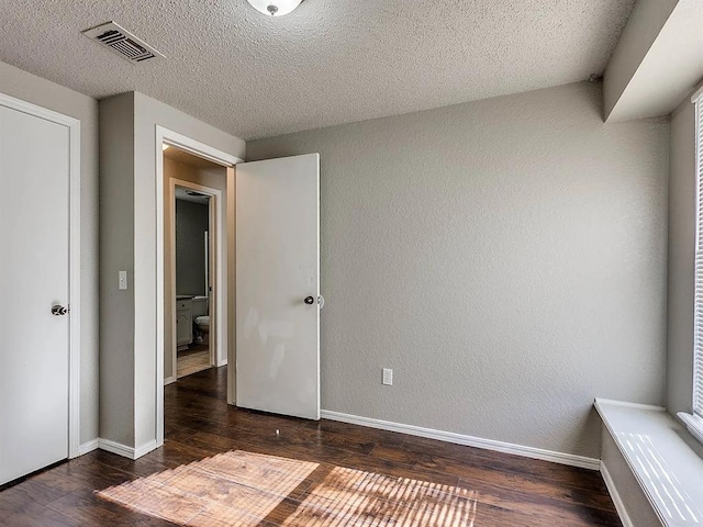 unfurnished bedroom featuring wood-type flooring, baseboards, and a textured ceiling