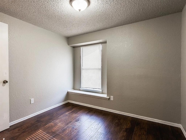 unfurnished room with wood finished floors, a textured wall, baseboards, and a textured ceiling