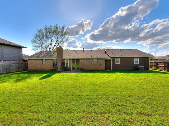 rear view of property featuring central AC, a chimney, and brick siding