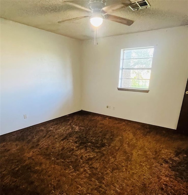 2217 7th St, Prague, OK 74864 - empty room with dark colored carpet, a textured ceiling, and ceiling fan