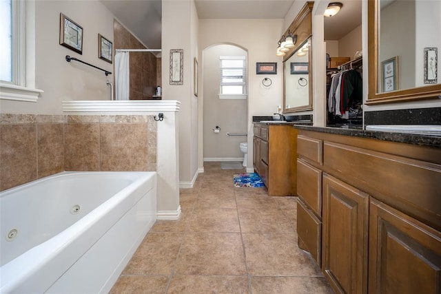 708 Carol Ann Pl, Moore, OK 73160 - bathroom featuring a jetted tub, toilet, tile patterned flooring, baseboards, and vanity