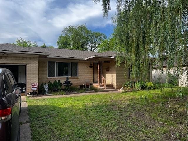 306 W Comanche St, Lindsay, OK 73052 - ranch-style house featuring brick siding, a garage, and a front lawn