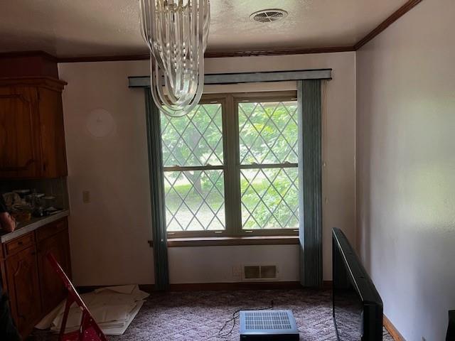 306 W Comanche St, Lindsay, OK 73052 - dining room with ornamental molding, plenty of natural light, a chandelier, carpet floors, and a textured ceiling