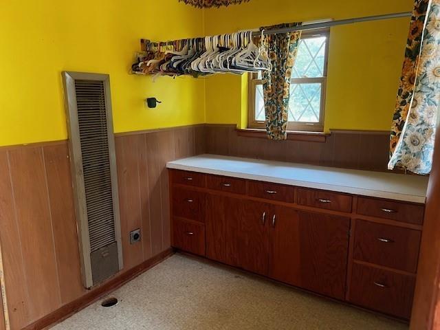 306 W Comanche St, Lindsay, OK 73052 - laundry area featuring a heating unit, a wainscoted wall, and wooden walls
