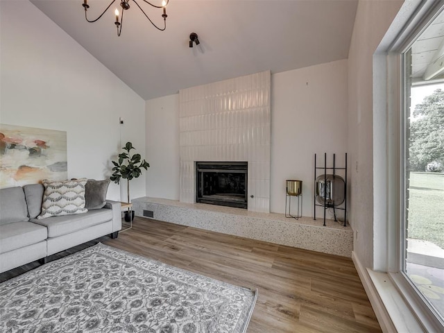 6401 Saddleback Dr, Oklahoma City, OK 73150 - living area featuring a chandelier, lofted ceiling, a fireplace, and wood finished floors