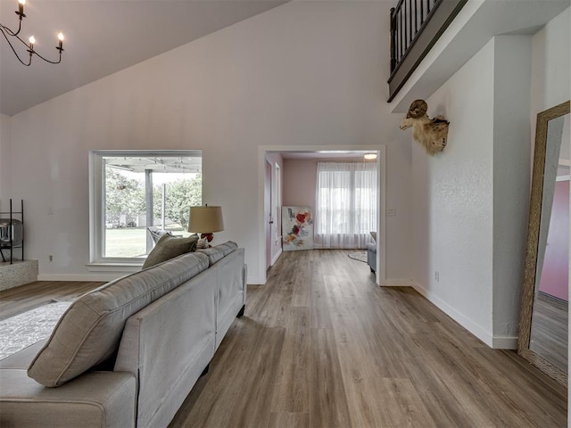 6401 Saddleback Dr, Oklahoma City, OK 73150 - living area with a chandelier, high vaulted ceiling, wood finished floors, and baseboards