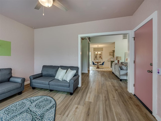 6401 Saddleback Dr, Oklahoma City, OK 73150 - living room with light wood-style flooring, ceiling fan, a chandelier, and baseboards