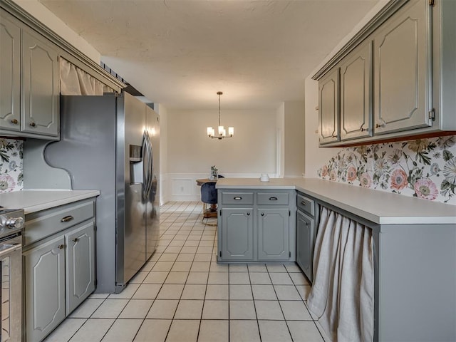 6401 Saddleback Dr, Oklahoma City, OK 73150 - kitchen featuring a peninsula, gray cabinets, a chandelier, a wainscoted wall, and light tile patterned flooring