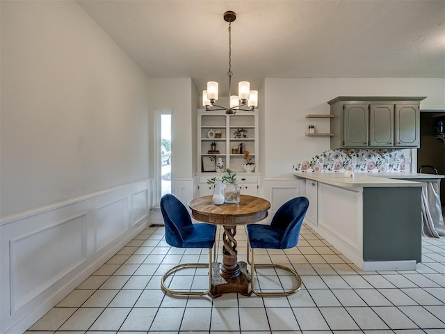 6401 Saddleback Dr, Oklahoma City, OK 73150 - dining area featuring a chandelier, wainscoting, a decorative wall, and light tile patterned flooring