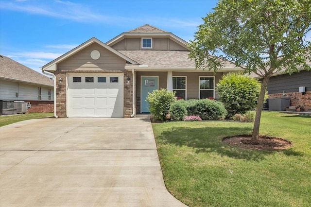 view of front facade with concrete driveway, a garage, a front yard, and cooling unit