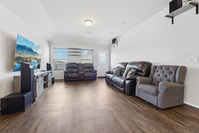 living room featuring dark wood finished floors, lofted ceiling, and baseboards