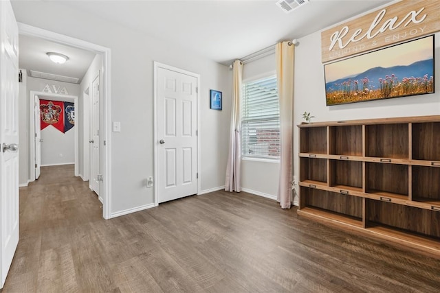 unfurnished bedroom with wood finished floors and baseboards