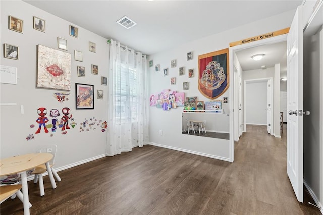 playroom with dark wood-type flooring and baseboards