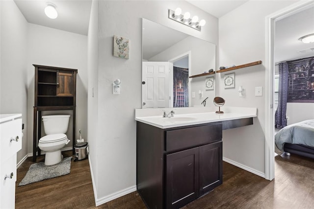 full bathroom featuring wood finished floors, toilet, vanity, and baseboards