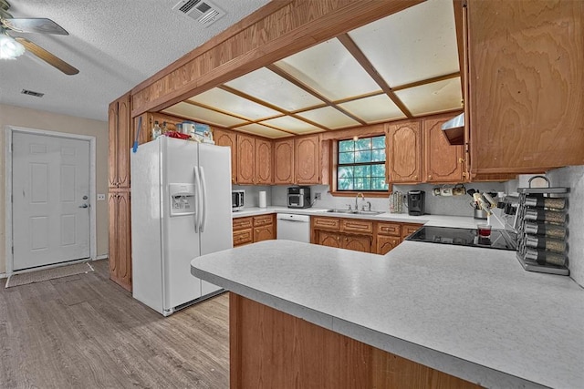 11402 N 1957th Rd, Elk City, OK 73644 - kitchen with white appliances, a ceiling fan, a peninsula, light wood-style floors, and light countertops