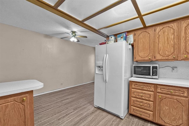 11402 N 1957th Rd, Elk City, OK 73644 - kitchen featuring white refrigerator with ice dispenser, stainless steel microwave, light wood-style flooring, ceiling fan, and light countertops