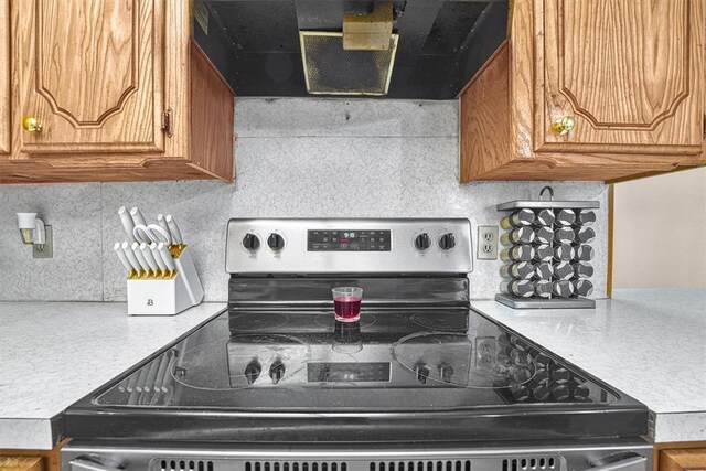 11402 N 1957th Rd, Elk City, OK 73644 - kitchen featuring electric range, exhaust hood, light countertops, and brown cabinetry