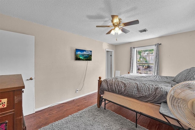 11402 N 1957th Rd, Elk City, OK 73644 - bedroom featuring wood finished floors, a textured ceiling, baseboards, and a ceiling fan