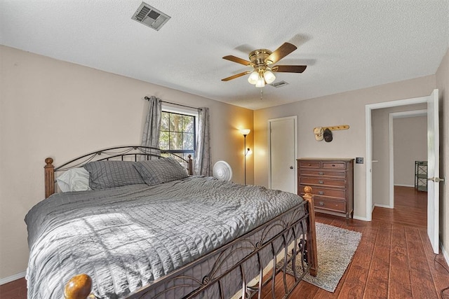 11402 N 1957th Rd, Elk City, OK 73644 - bedroom with wood finished floors, a textured ceiling, baseboards, and ceiling fan