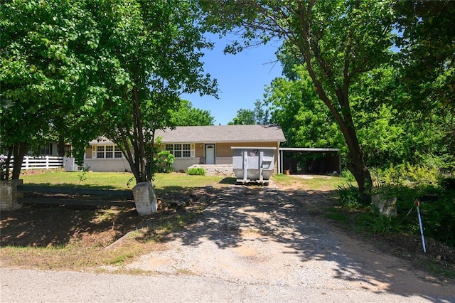 ranch-style home with driveway and fence