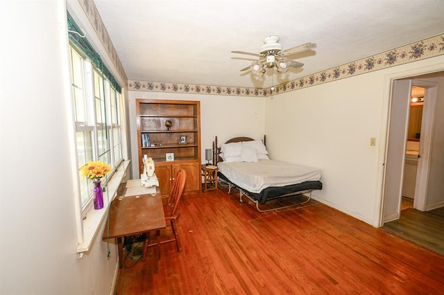bedroom featuring wood finished floors, baseboards, and a ceiling fan