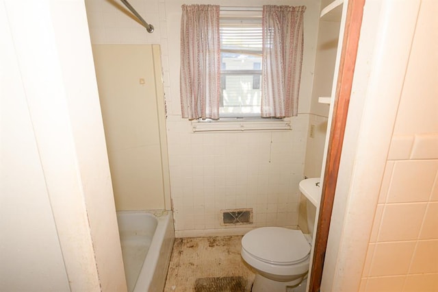 full bathroom featuring tile walls, toilet, a shower, and a bathtub
