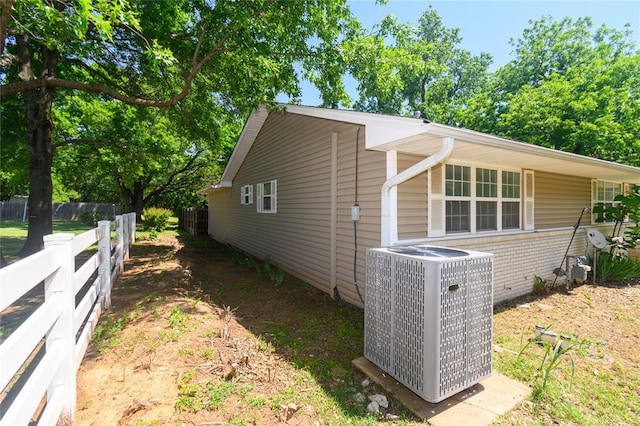 view of home's exterior featuring central AC and fence