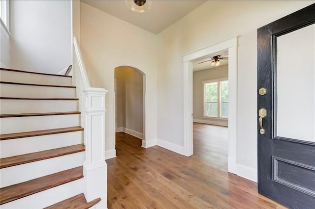 312 S Ash St, Guthrie, OK 73044 - foyer with arched walkways, wood finished floors, stairway, a ceiling fan, and baseboards