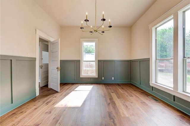 312 S Ash St, Guthrie, OK 73044 - unfurnished dining area featuring a decorative wall, a chandelier, a wainscoted wall, and hardwood / wood-style floors